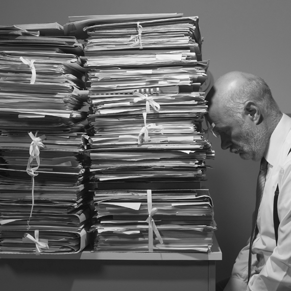 A man with his head leaned against a stack of newspapers